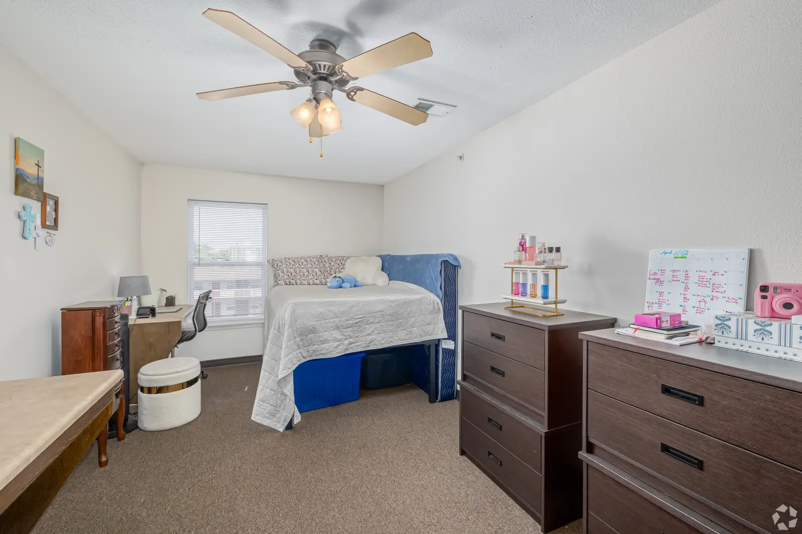 Bedroom at The Jefferson with bed, desk area, dressers, window, and ceiling fan